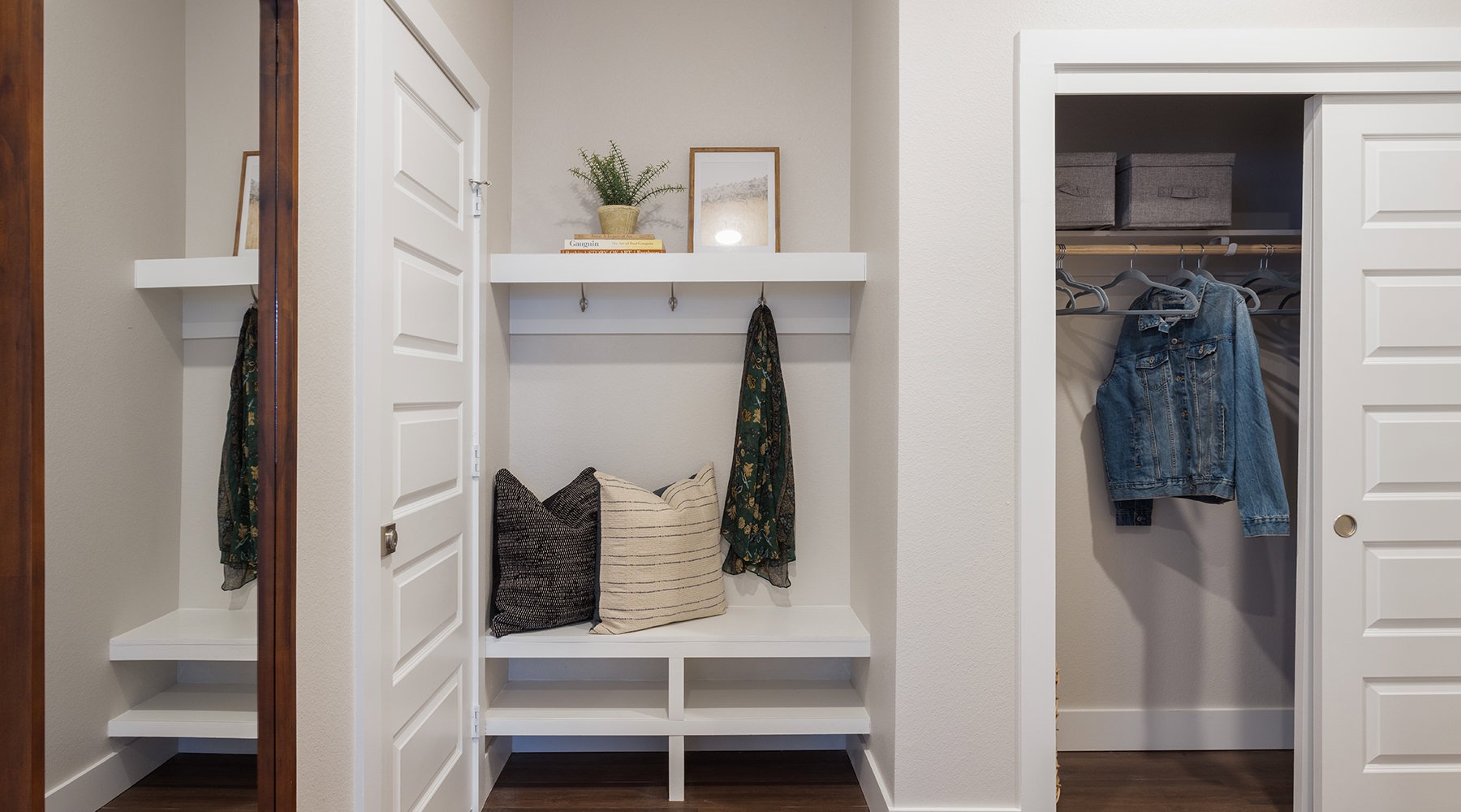 view of closet and mirror with place to sit and hang coat